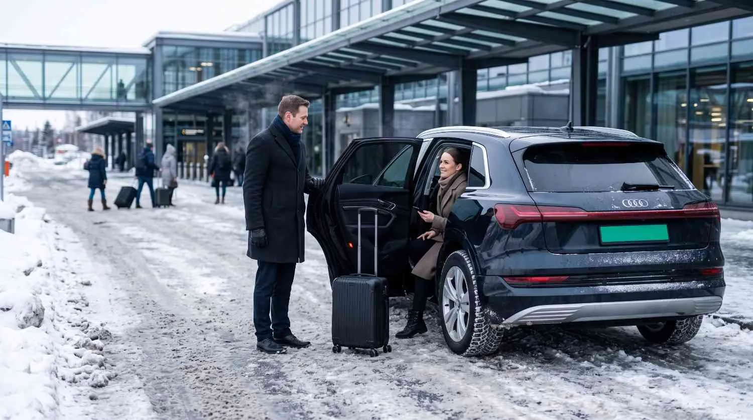 Chauffeur helping a passenger into a car on a snowy winter day